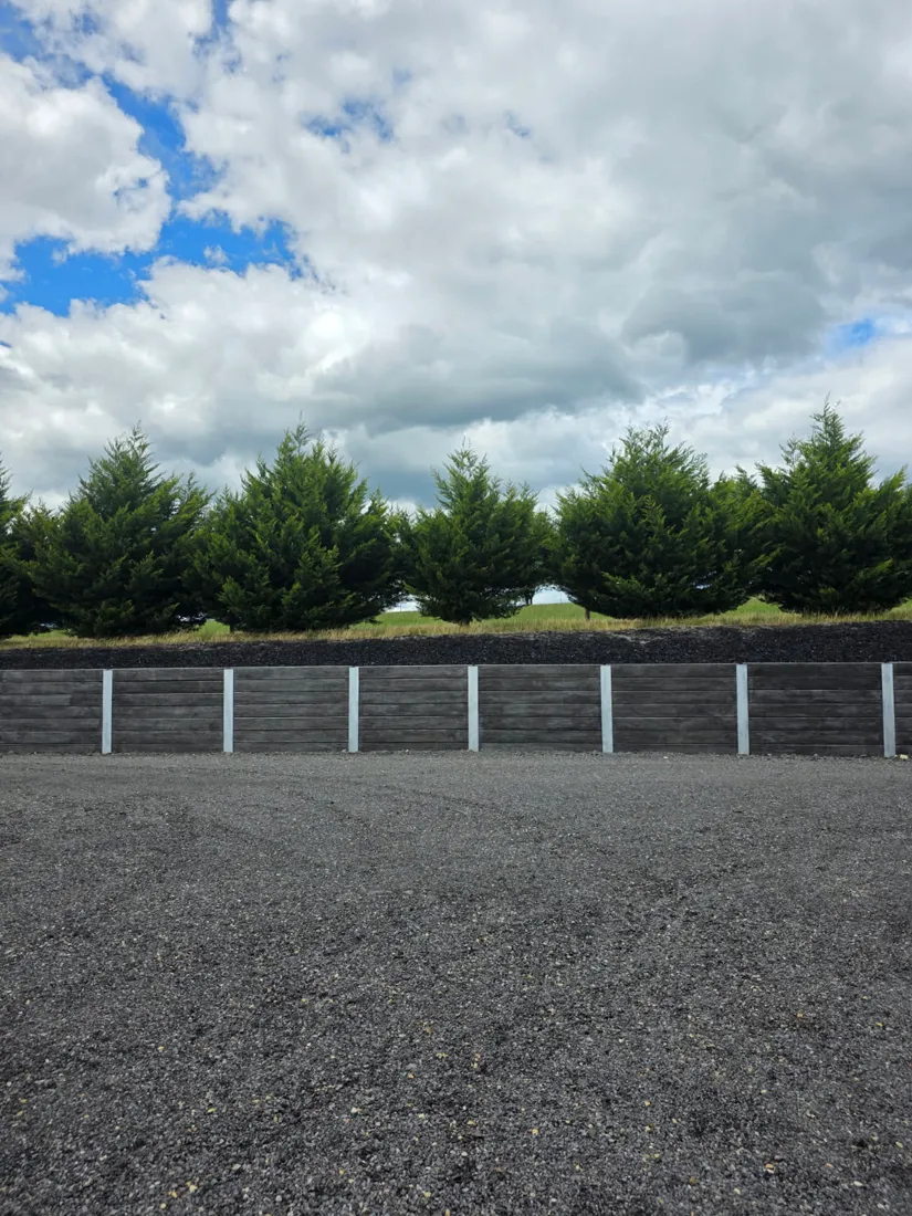 Finished charcoal sleeper retaining wall by a street